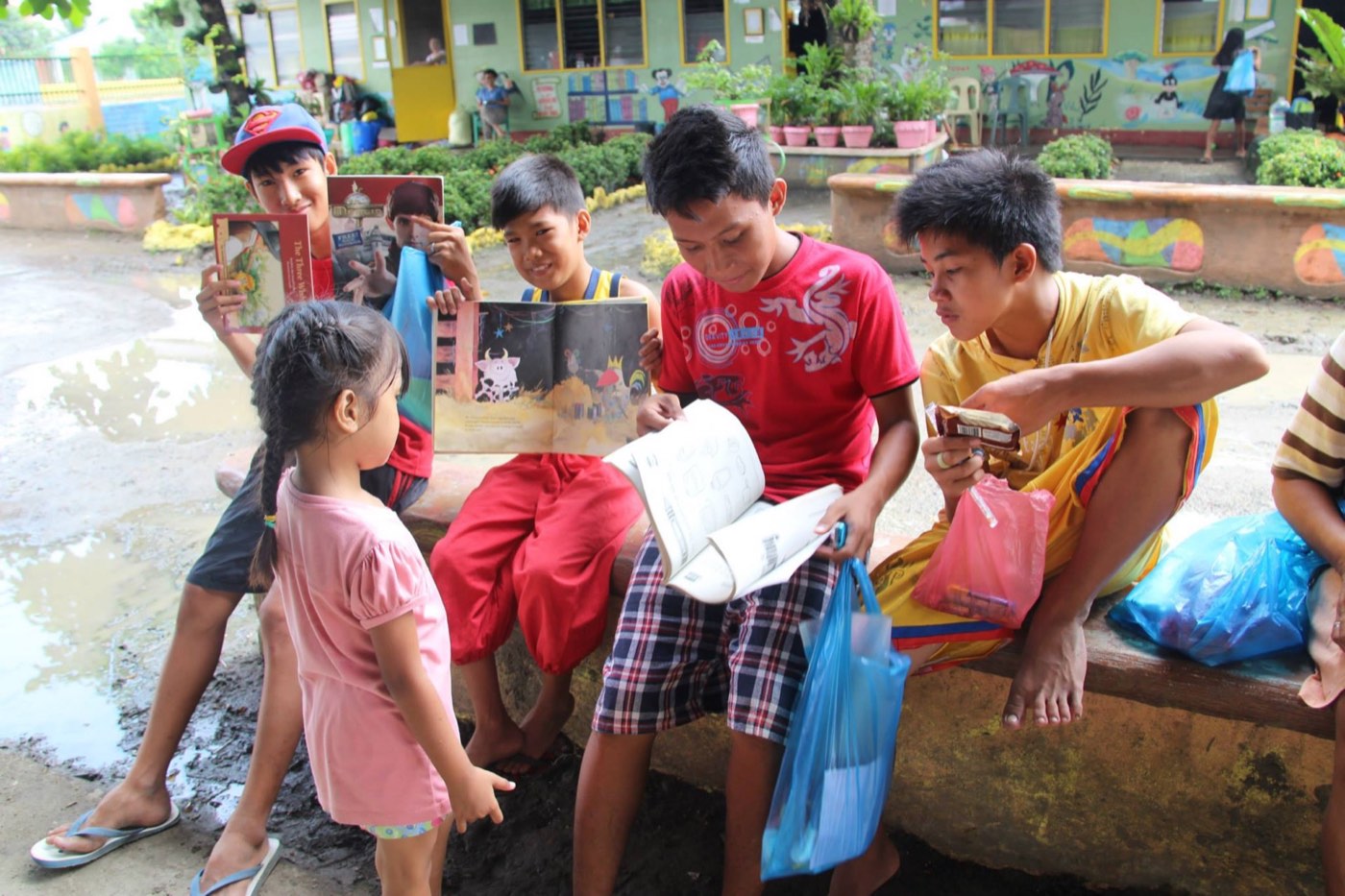 Children read storybooks distributed by KRIS in a community outreach visit.